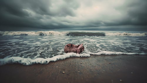 En sandal har flutit upp på en strand av vågor.