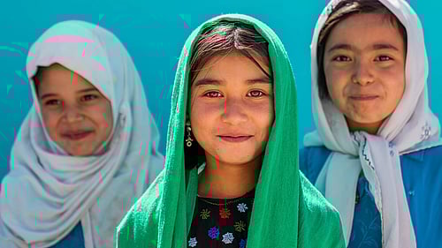 Ge barn på flykt skolpaket med pennor, böcker och ryggsäck.