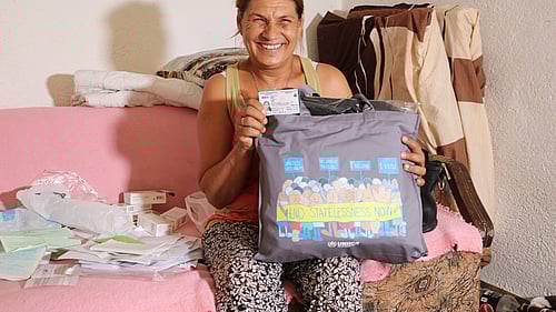 En kvinna som tidigare varit statslös visar upp sitt nya ID-kort.