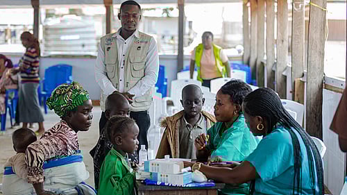 En familj sitter runt ett bord, tillsammans med UNHCR-medarbetare.