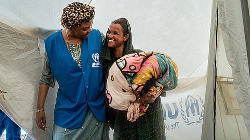 UNHCR:s fältarbetare håller om en kvinna på flykt.