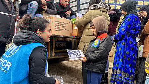 En kvinnlig UNHCR-medarbetare pratar med ett barn i Bangladesh.