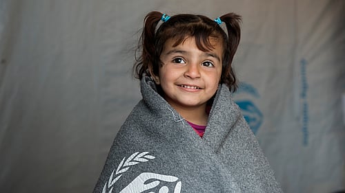Amira är på flykt från Syrien. Hon har fått en tjock filt som hjälper under kyliga nätter i tält. Vill du värma en familj?