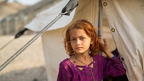 En flicka på flykt återvänder hem från Pakistan till Afghanistan. Här står hon utanför ett UNHCR-tält i Afghanistan nära gränsen till Pakistan.