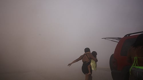 Jordbävning i Venezuela. A woman runs with a kid to take cover during an earthquake, in La Guaira, Venezuela, June 24, 2026. Foto: REUTERS/Maxwell Briceno