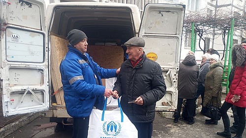 UNHCR lämnar över förnödenheter till en äldre man i Kherson, Ukraina.