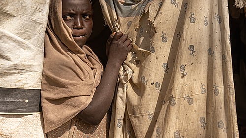 10-åriga Maha tittar ut från sitt boende i ett flyktingläger i nordvästra Etiopien. Hon, hennes syskon, mamma och mormmor har flytt undan våldet i Sudan. Foto: UNHCR/Tiksa Negeri