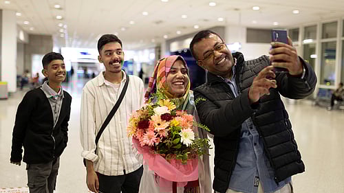 En rohingya-familj återförenas på flygplatsen, de ler in i en kamera.