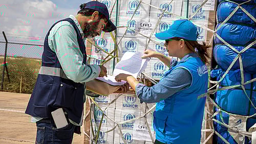 UNHCR-personal checkar av en lista vid en fraktpall med nödhjälpsartiklar.