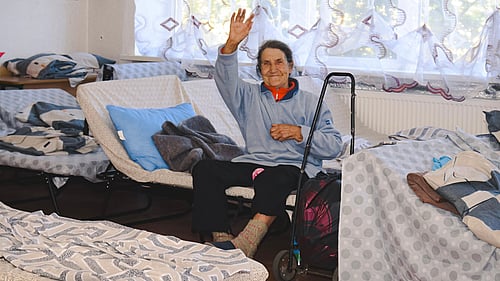 En kvinna sitter på en säng i Ukraina.