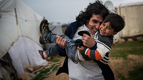 Två bröder leker och kramas i ett flyktingläger i Libanon.