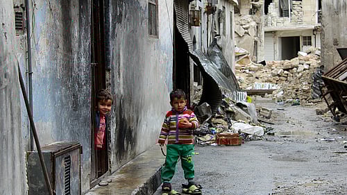 Ramadan är extra svår för familjer på flykt - utan mat och skydd. En liten pojke står i ruinerna i Syrien.