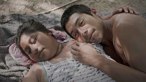 Ett foto från utställningen, en man och en kvinna ligger ner och blundar intill varandra.