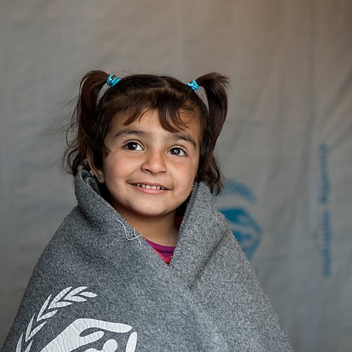 En flicka på flykt från Syrien har fått en varm filt. Du kan hjälpa fler att hålla värmen. Köp gåvobevis Filtpaket och rädda liv.