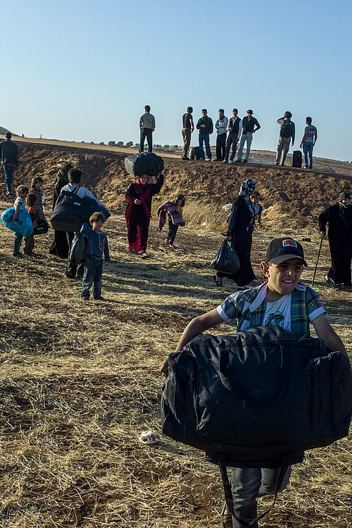 En pojke bär en väska när han flyr från Syrien.