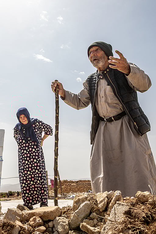 En äldre man och kvinna står utanför ett tält i Syrien.