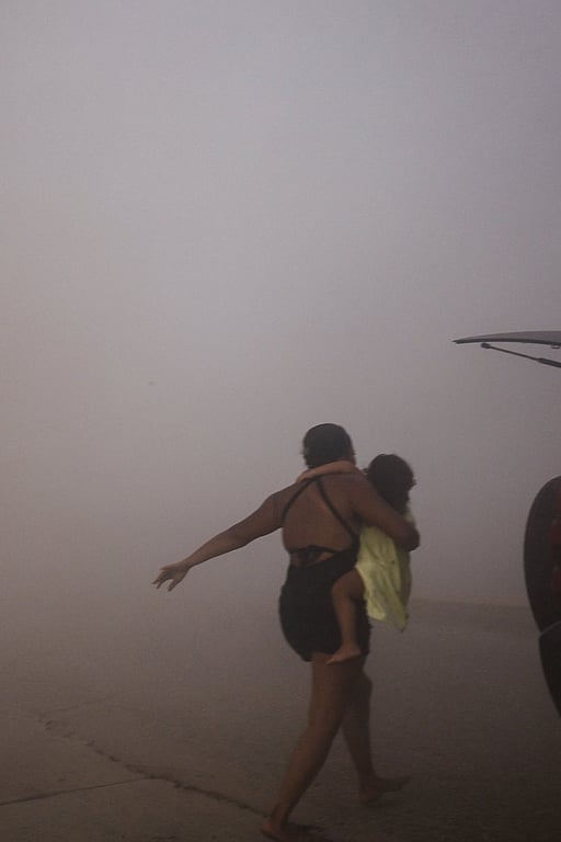 Jordbävning i Venezuela. A woman runs with a kid to take cover during an earthquake, in La Guaira, Venezuela, June 24, 2026. Foto: REUTERS/Maxwell Briceno