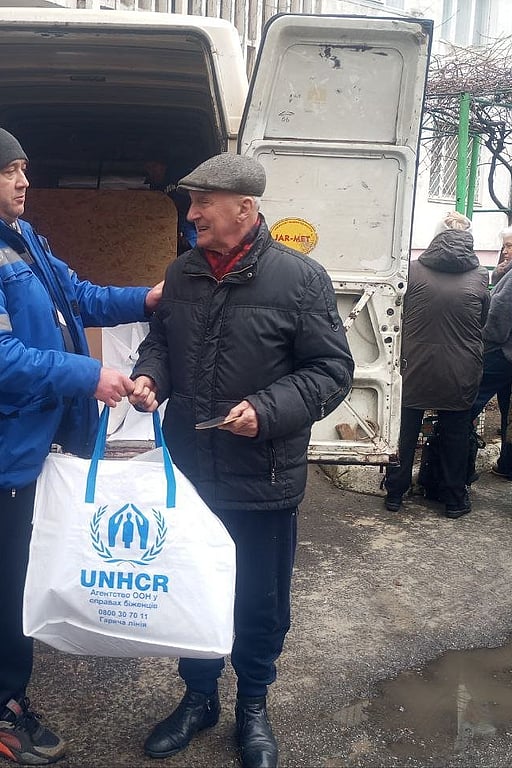 UNHCR lämnar över förnödenheter till en äldre man i Kherson, Ukraina.