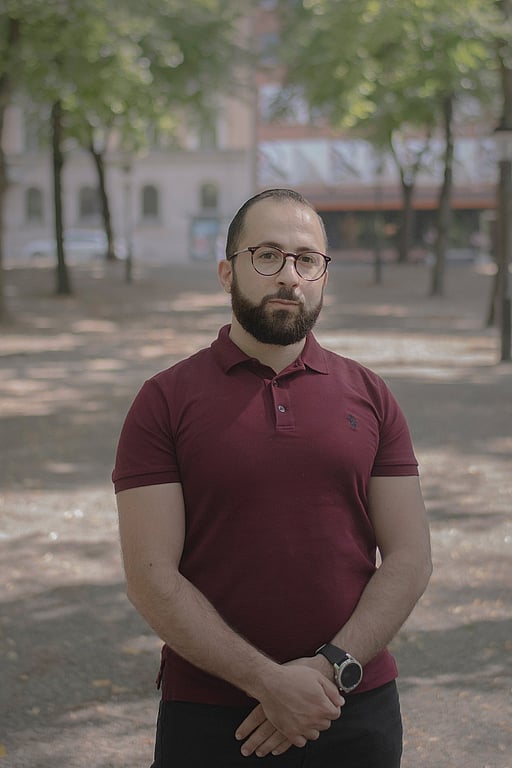 En man i mörkröd tröja står på en grusväg.