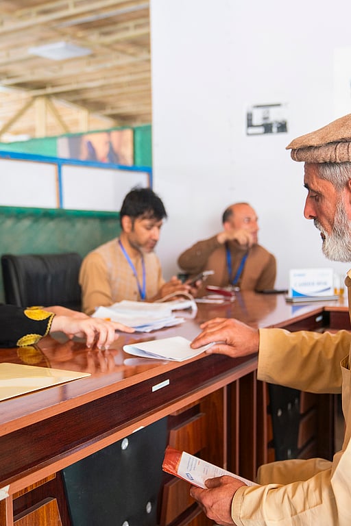 Bild från ett mottagningcenter i Afghanistan, där en man tar emot hjälp från administrationen.