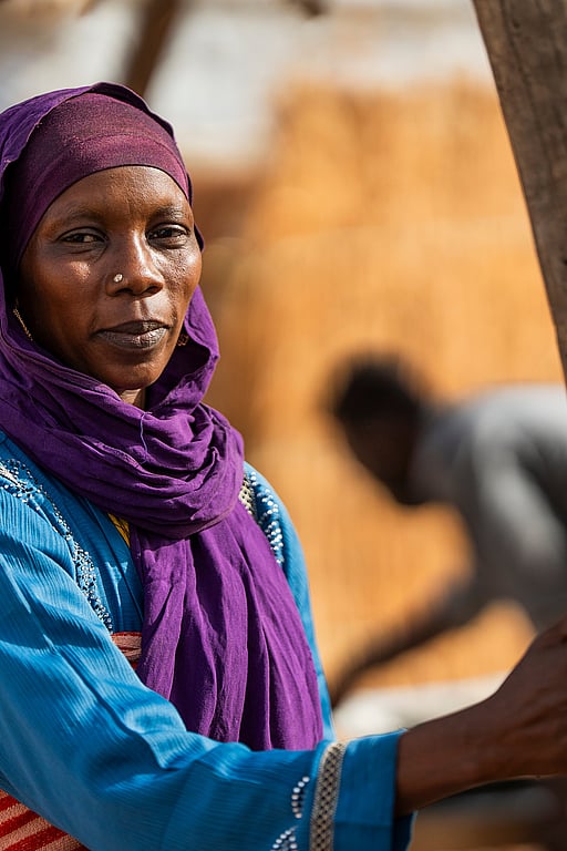 En sudanesisk kvinna. Hon tittar in i kameran och ser allvarsam ut.