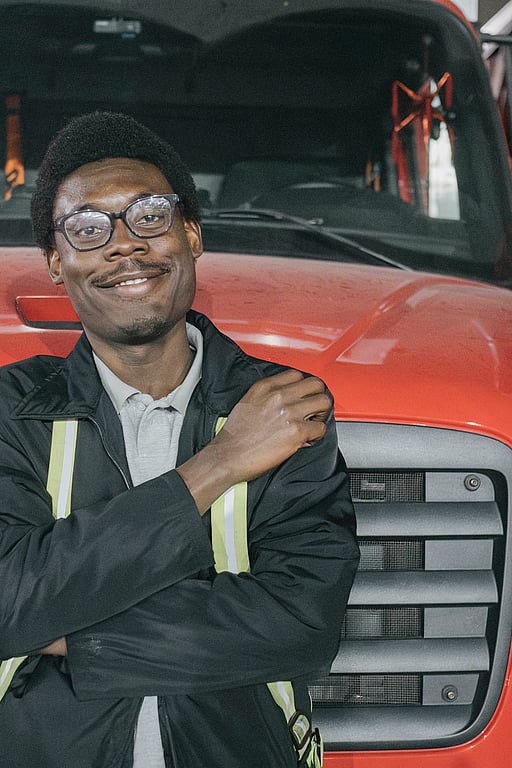 En man framför en röd bil.