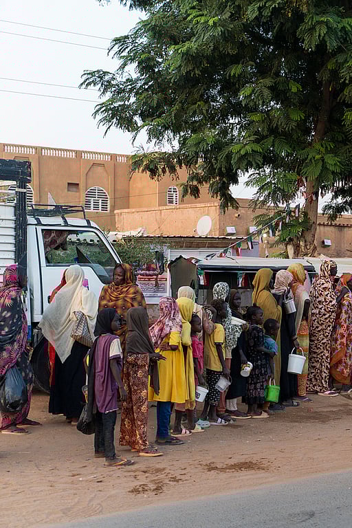 Människor som flytt kriget står i en kö för att få matutdelning.