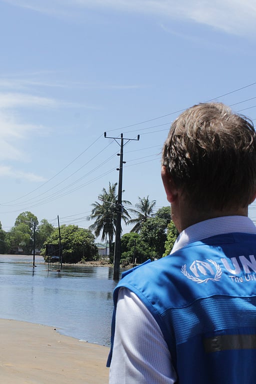 En hjälparbetare blickar ut över en översvämmad gata.