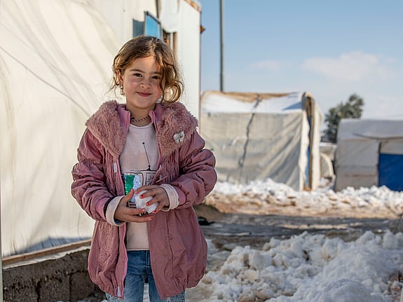 UNHCR-personal skakar hand framför en försändelse med nödhjälp.