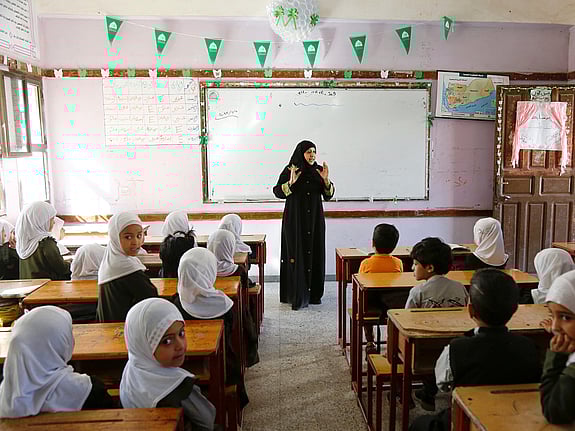 En kvinnlig lärare står framför sina elever.