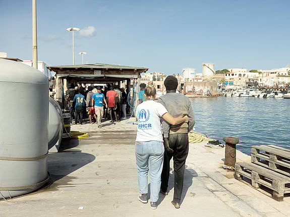 UNHCR-personal hjälper en flykting som kommit i land på Lampedusa.
