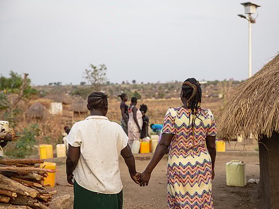 Två personer går hand i hand i riktning bort från kameran.