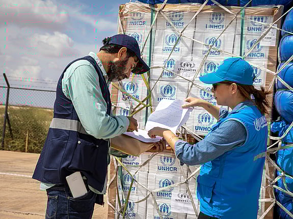 UNHCR-personal checkar av en lista från en försändelse med nödhjälp.