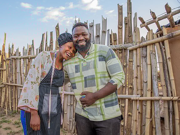 En man och en kvinna håller om varandra och skrattar. De är flyktingar från Demokratiska republiken Kongo.