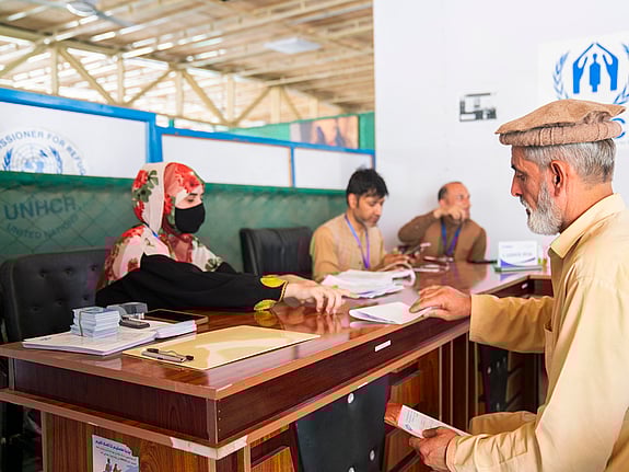 Bild från ett mottagningcenter i Afghanistan, där en man tar emot hjälp från administrationen.
