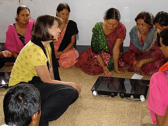 En kvinna demonstrerar en Solvattendunk för en grupp kvinnor i Nepal.