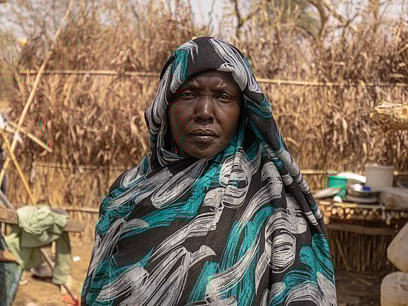 40-åriga Maha står bredvid sitt boende i ett flyktingläger i nordvästra Etiopien. Hon, hennes barn och mamma har flytt undan våldet i Sudan. Foto: UNHCR/Tiksa Negeri