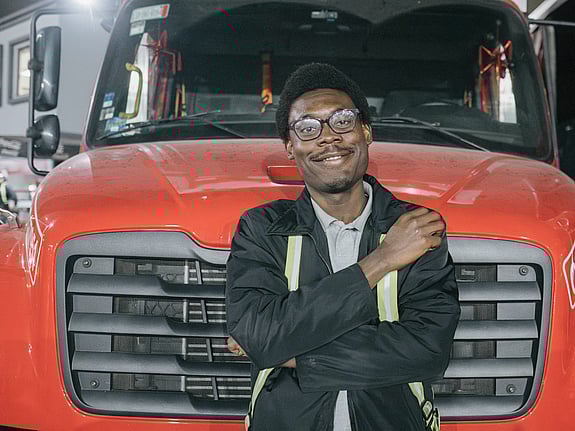 En man framför en röd bil.