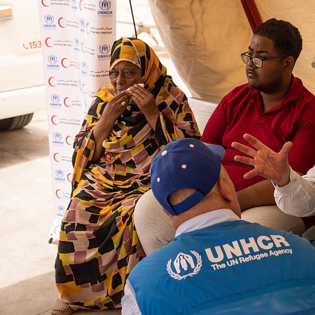 Flera människor sitter runt ett bord och diskuterar.