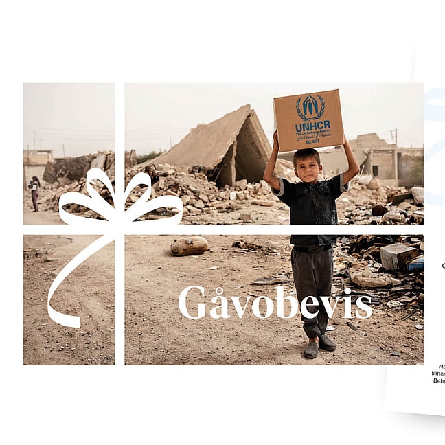 Fotografi på ett gåvobevis där en pojke bär på ett paket med förnödenheter.