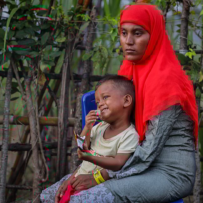 En kvinna håller sin son i famnen.