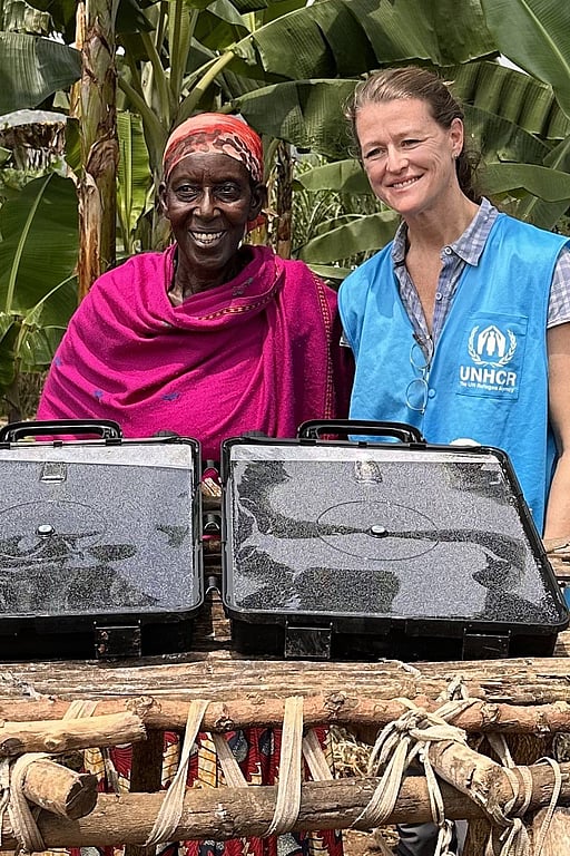 Två kvinnor står framför en solvatten-dunk och ler.
