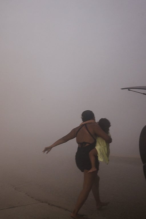 Jordbävning i Venezuela. A woman runs with a kid to take cover during an earthquake, in La Guaira, Venezuela, June 24, 2026. Foto: REUTERS/Maxwell Briceno