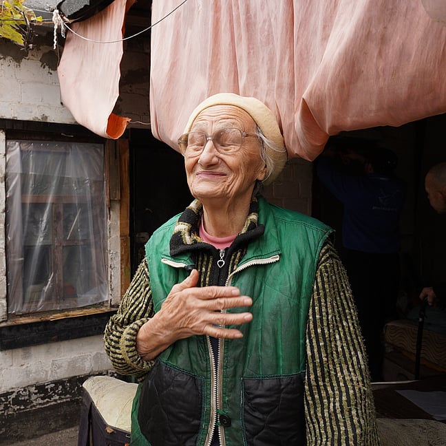 Ukrainsk kvinna framför sitt hus