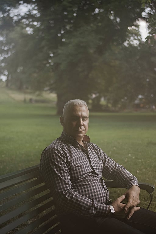En man sitter på en parkbänk.