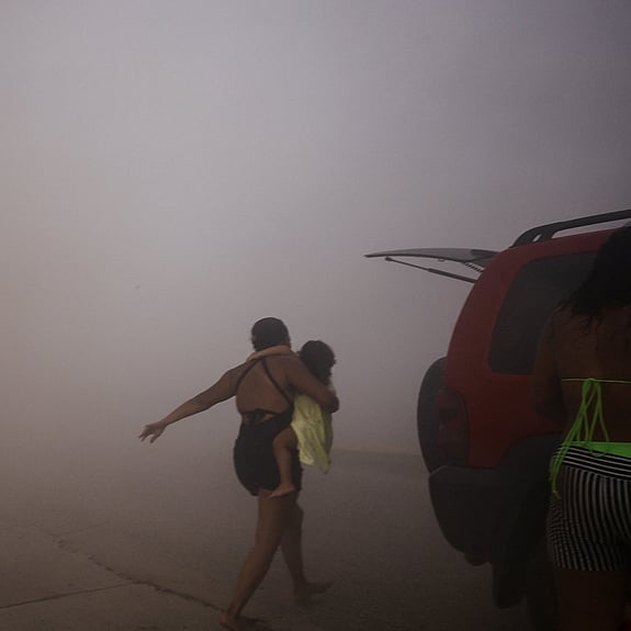 Jordbävning i Venezuela. A woman runs with a kid to take cover during an earthquake, in La Guaira, Venezuela, June 24, 2026. Foto: REUTERS/Maxwell Briceno
