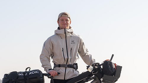 En man står vid sin cykel.