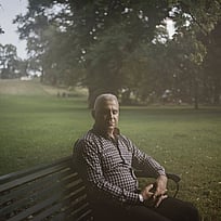 En man sitter på en parkbänk.