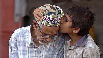 En morfar får en puss av sitt barnbarn.