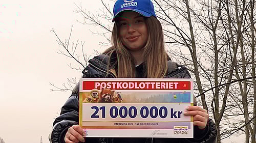 Maria Sur håller en check från Postkodlotteriet.